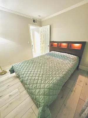 a bedroom with a bed with a green comforter at Spacious and Exclusive Oasis 6BR 3BA in Thousand Oaks