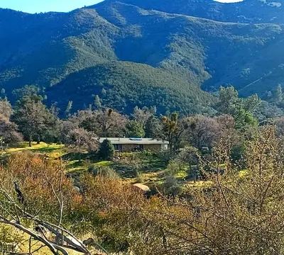 a house on a hill in front of a mountain at Secluded Oasis with View, and hot tub on 50 acres in Bodfish