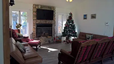 a living room with a christmas tree and a fireplace at Secluded Oasis with View, and hot tub on 50 acres in Bodfish