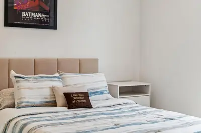 a bedroom with a bed with a blanket and pillows at NoHo Modern Townhouse with Gorgeous Rooftop in Van Nuys