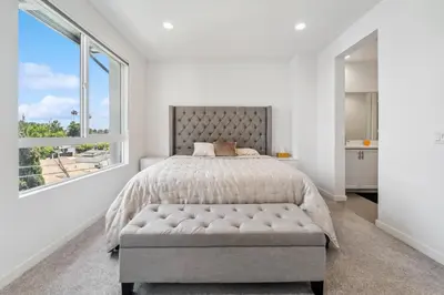 a bedroom with a bed and a large window at NoHo Modern Townhouse with Gorgeous Rooftop in Van Nuys