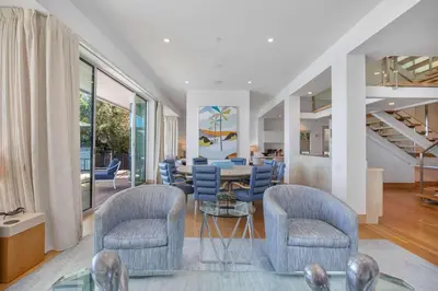 a living room with blue chairs and a table at Casa Mare by Stay Awhile Villas in Malibu Beach