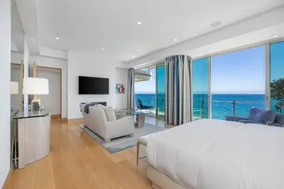 a bedroom with a large bed and a view of the ocean at Casa Mare by Stay Awhile Villas in Malibu Beach