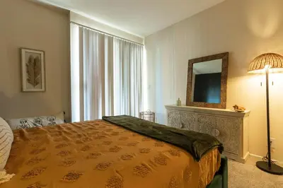 a bedroom with a bed and a mirror and a lamp at Marvelous 2BR 2BA Apartment in Los Angeles