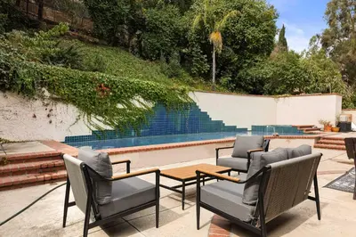 a patio with chairs and a table and a pool at Allura Studio City Mediterranean with Private Pool in Los Angeles