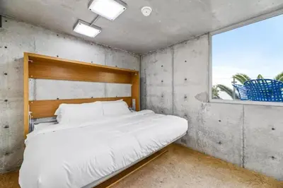 a bedroom with a large white bed with a window at Broad Beach Wdirect Beach Access in Malibu