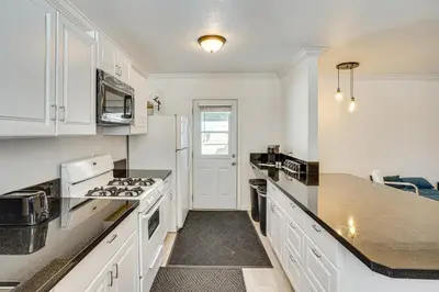 a kitchen with white cabinets and a stove top oven at Between LA and Orange County Quiet Getaway with Patio in Pico Rivera
