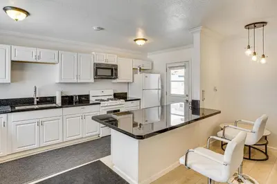 a kitchen with white cabinets and white appliances at Between LA and Orange County Quiet Getaway with Patio in Pico Rivera