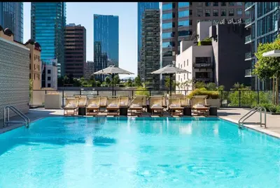 a large pool with chairs and umbrellas on a building at 2BR Panoramic City View!! in Los Angeles