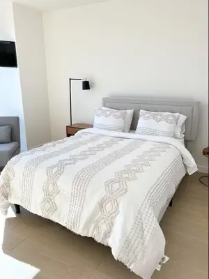 a white bed with a white comforter and pillows at Luxury Vacation Resort Studio Downtown LA in Los Angeles