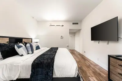a bedroom with a large bed and a flat screen tv at Spacious 2 Bedroom Condo in DTLA, Large Private Patio, Pets Welcomed in Los Angeles