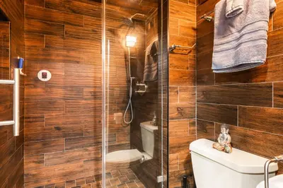 a bathroom with wooden walls and a shower with a toilet at Spacious 2 Bedroom Condo in DTLA, Large Private Patio, Pets Welcomed in Los Angeles