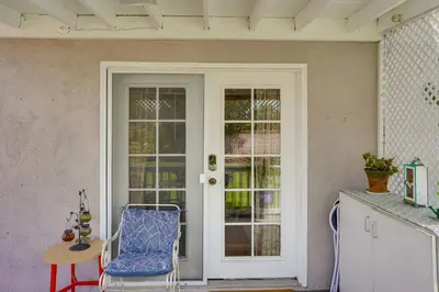 a porch with a door and a chair and a table at Cozy Couples Oasis with Pool 3 Mi to Disneyland! in Garden Grove