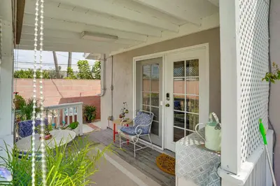 a porch with a blue chair and a table at Cozy Couples Oasis with Pool 3 Mi to Disneyland! in Garden Grove