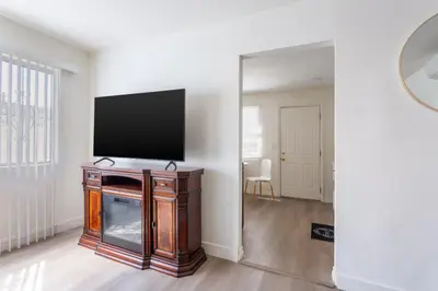 a living room with a flat screen tv and a mirror at Stylish2BR Patio BBQ Parking Downtown LA in Los Angeles