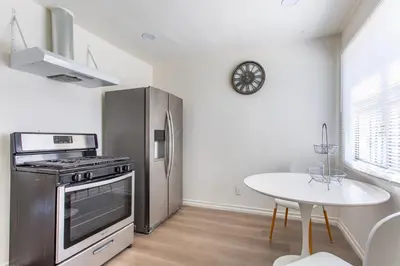 a kitchen with a stainless steel refrigerator and a table at Stylish2BR Patio BBQ Parking Downtown LA in Los Angeles