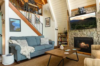 a living room with a blue couch and a fireplace at Casa Huntsted A-Frame Cabin near Snow Valley in Running Springs