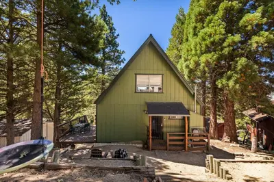 a green house in the middle of trees at Casa Huntsted A-Frame Cabin near Snow Valley in Running Springs