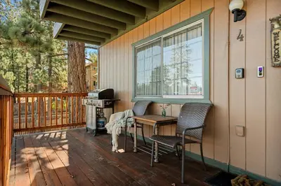 a porch with two chairs and a table and a grill at The Pinnacle steps to the ski lifts in Big Bear Lake