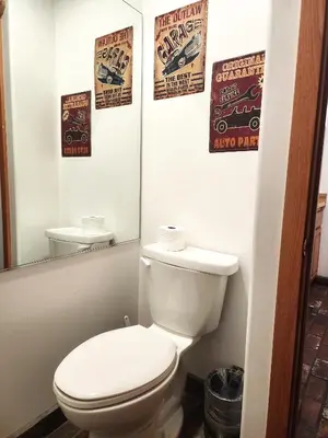 a bathroom with a toilet and posters on the wall at Creek Runner Lodge in Big Bear Lake