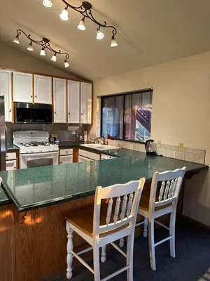 a kitchen with a large counter with two chairs at a table at Home Sweet Home in Frazier Park