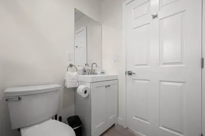 a white bathroom with a toilet and a sink at Niagara Haven in Burbank