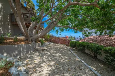 a tree in front of a building with a fence at Weho Sunset Strip Hideaway And Casita in Los Angeles