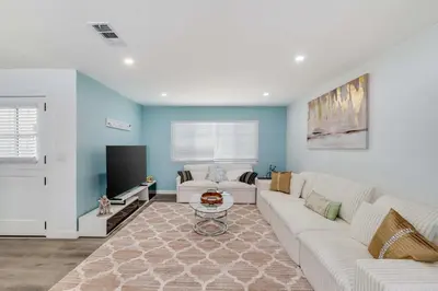 a living room with a white couch and a tv at 4BR Escape - Mtn Views Private BBQ in Thousand Oaks