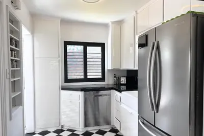 a white kitchen with a stainless steel refrigerator at Rad Stay Open Concept House in Mar Vista in Los Angeles