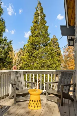 a yellow bird bath sitting on a deck with a tree at The Crown A-Frame Gated Central AC Lake Access in Lake Arrowhead