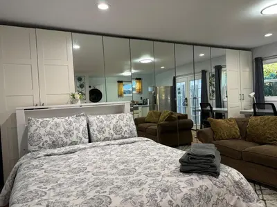 a bedroom with a bed and a large mirror at Modern Studio with Private Patio in Los Angeles