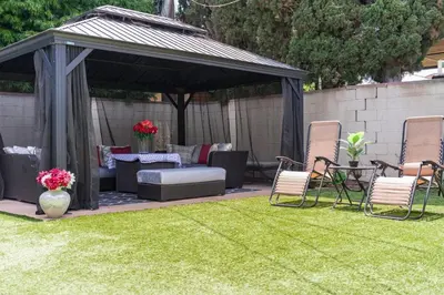 a gazebo with chairs and a table on a lawn at Cute Studio with AC and Backyard in Los Angeles