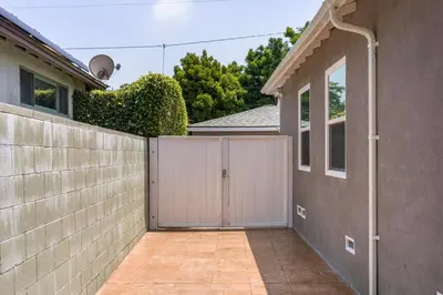 a fence with a gate in front of a house at Cute Studio with AC and Backyard in Los Angeles
