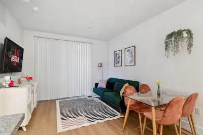 a living room with a green couch and a table at 2BR Coastal Retreat Walk to Beach, free parking in Los Angeles