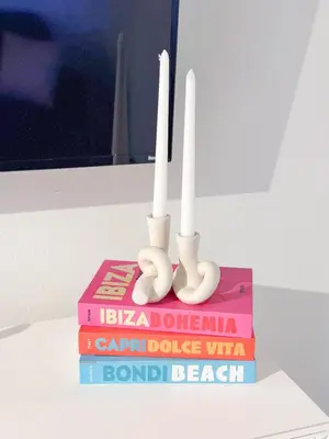 two white candles sitting on top of books at 2BR Coastal Retreat Walk to Beach, free parking in Los Angeles