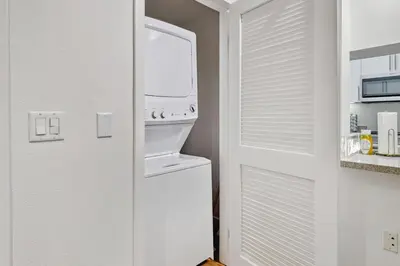 a white refrigerator freezer next to a white door at 2BR Coastal Retreat Walk to Beach, free parking in Los Angeles