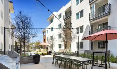 a patio with a table and chairs and umbrellas at Noho Alexan Modern 2bed Duo with FREE Parking in Garnsey
