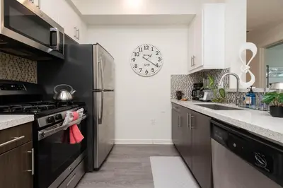 a kitchen with a stove and a clock on the wall at Hollywood Stars 2 Bedroom Apartment in Los Angeles