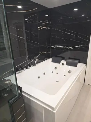 a white bath tub in a bathroom with black walls at Soft elegance, modern guest house in Alhambra