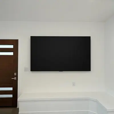 a flat screen tv hanging on a white wall at Soft elegance, modern guest house in Alhambra