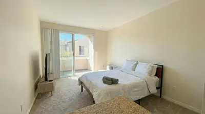 a bedroom with a bed and a television and a window at Marina Del Rey Sunrise - Pool & Gym & Sauna & Cinema in Marina del Rey