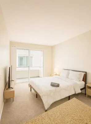 a white bedroom with a large bed and a television at Marina Del Rey Sunrise - Pool & Gym & Sauna & Cinema in Marina del Rey