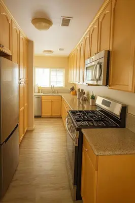 a kitchen with wooden cabinets and a stove top oven at Modern Comfort near Universal in Los Angeles