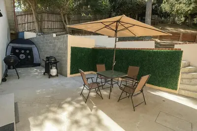 a table and chairs with an umbrella on a patio at Modern Comfort near Universal in Los Angeles