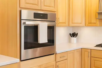 a stainless steel oven in a kitchen with wooden cabinets at Fullerton Disneyland Getaway - 4BR in Fullerton
