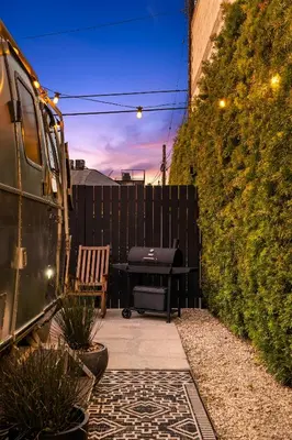 a backyard patio with a grill and a fence at Hip Venice Beach Luxury Airstream & Creative Space in Los Angeles