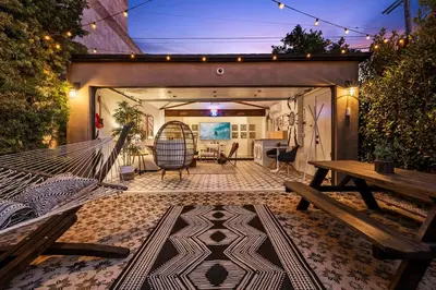 a hammock in a patio with a table and bench at Hip Venice Beach Luxury Airstream & Creative Space in Los Angeles