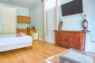 a bedroom with a bed and a dresser with a flat screen tv at Malibu 2BR In Woods Close To Beach in Malibu