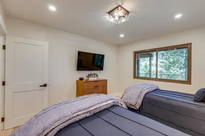 a bedroom with two beds and a tv at Stunning Forest Views Luxury Lake Arrowhead Cabin in Lake Arrowhead