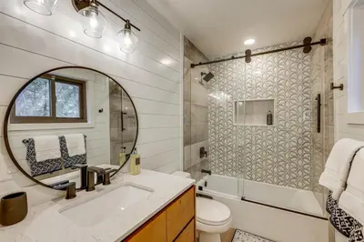 a bathroom with a sink and a tub and a mirror at Stunning Forest Views Luxury Lake Arrowhead Cabin in Lake Arrowhead